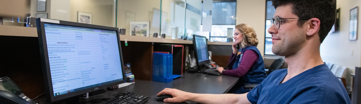 a male receptionist reading a page on a screen spokane eye clinic