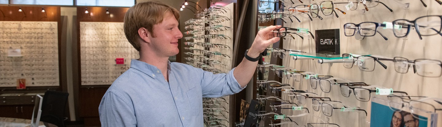 a man selecting a pair of eyeglass frames spokane eye clinic