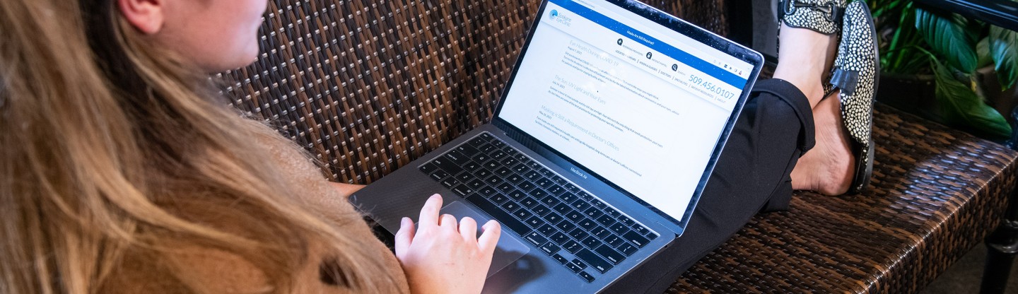 a woman viewing the website on a laptop spokane eye clinic